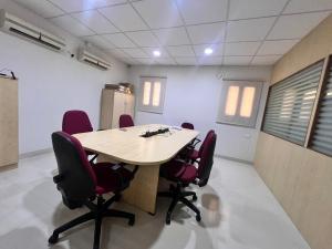 een conferentieruimte met een houten tafel en rode stoelen bij Padma Homes Stay- Luxury Service Apartment 1BHK & 2BHK & 3BHK in Tirupati