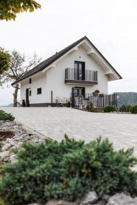 een wit huis met een grote oprit bij Tanja s Holiday Home in Nature with sauna and hot tub in Gorica pri Slivnici