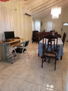 Tropical Blessings - Ocho Rios في سانت ماري: غرفة معيشة مع طاولة وكراسي وجهاز كمبيوتر محمول