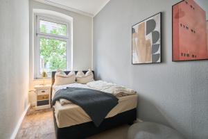 a small bedroom with a bed and a window at Cityapartment für bis zu 8 Personen in Berlin