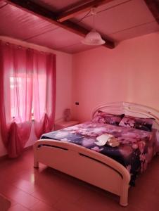 - une chambre avec un lit aux murs roses et des rideaux roses dans l'établissement Appartamento mare, à Siderno Marina