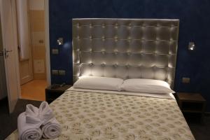 a large bed with a large headboard in a bedroom at Hotel La Madonnina in Milan