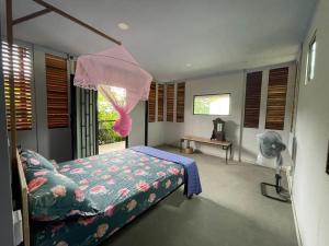 um quarto com uma cama de dossel rosa em Blue Indigo yoga Cambodia em Phnom Penh
