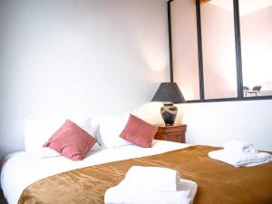 a bedroom with a bed with two towels on it at Les Comtes de Toulouse in Roquemaure