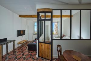 a living room with a table and a room with a fish tank at Les Comtes de Toulouse in Roquemaure