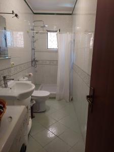 La salle de bains blanche est pourvue d'un lavabo et de toilettes. dans l'établissement Lovely 11 Rental Ap In Myslym Shyri Tirana, à Tirana