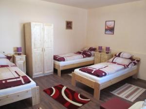 um quarto com três camas num quarto em Tavi Fészek Vendégház em Bánk