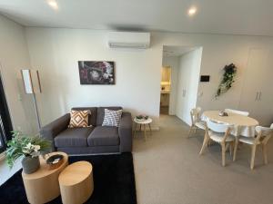 a living room with a couch and a table at Spacious1 BR@waterfront Olympic Park_free carpark in Sydney