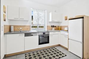 a kitchen with white appliances and a checkered floor at Erholung pur nahe Krankenhaus & Park mit Parkplatz in Graz