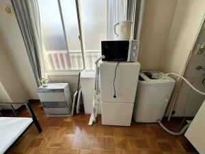 a room with a microwave on top of a refrigerator at カプリス豊平公園201号室 in Toyohira