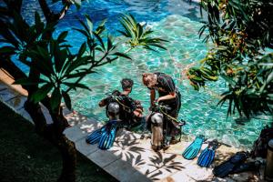 Kura Kura Divers Lodge في آميد: رجل على دراجة نارية في حمام سباحة