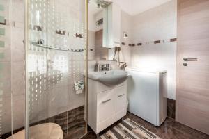 a white bathroom with a sink and a shower at Apartments & Room Anita in Rovinj +136 photos