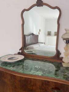 a bedroom with a large mirror on a table at La casa di Nonna Celeste in Brindisi