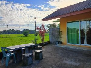 a picnic table and chairs in front of a house at Six Nature Resort in Chiang Rai
