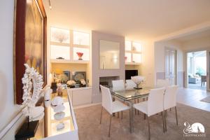 馬內爾巴德爾加爾達的住宿－Villa Luisa，用餐室以及带玻璃桌和白色椅子的客厅。