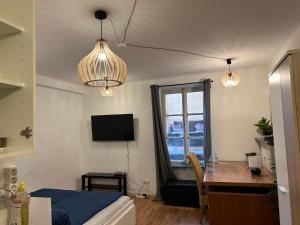 a bedroom with a bed and a desk and a window at Trier City Center Apartments Altstadt in Trier