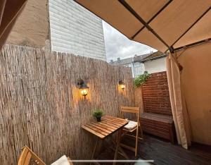a patio with a wooden table and a brick wall at Trier City Center Apartments Altstadt in Trier