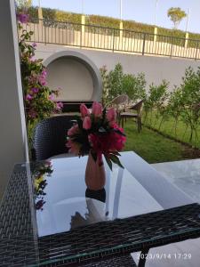 um vaso de flores sentado em uma mesa com um laptop em OpenSpace 50 mq con Giardino em Sharm el Sheikh