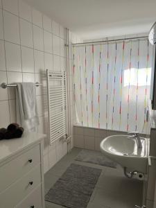y baño blanco con lavabo y ducha. en Lorraine en Berna
