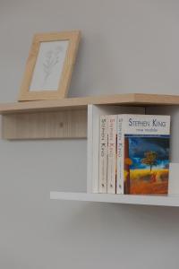 a shelf with books and a picture on it at Spacious Apartment for 6 Guests in Krakow with Home Office by Renters in Krakow