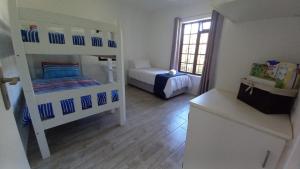 a small room with two bunk beds and a window at Hidden Cottage in Bredasdorp