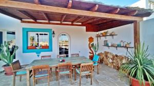 - une salle à manger avec une table et des chaises en bois dans l'établissement Caleta Beach House, à Caleta de Fuste