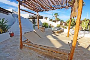 - une terrasse avec un lit et un parasol en bois dans l'établissement Caleta Beach House, à Caleta de Fuste