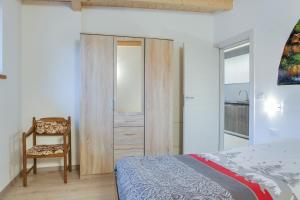 - une chambre avec un lit, une chaise et un miroir dans l'établissement Sas Lonch, à Pera