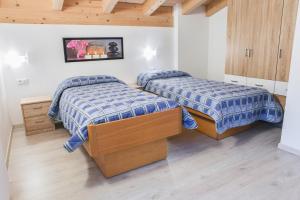 a bedroom with two beds and a wooden ceiling at Ciampedie in Pera