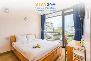 een slaapkamer met een bed en een groot raam bij Vuon Xuan Hotel - STAY 24H in Da Lat