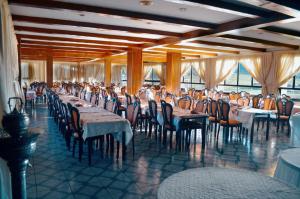 a dining room with tables and chairs and windows at Amrouss touristic DarMaroc in Azrou
