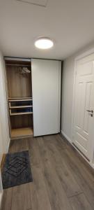 ein leeres Zimmer mit einem Schrank und einer Tür in der Unterkunft Lille huset in Holmestrand