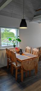 una mesa de comedor de madera con sillas y una maceta en Lille huset, en Holmestrand