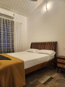 a bedroom with a bed and a blue curtain at vintage valley urban cottage in Thodupuzha