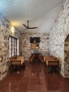 Thodupuzhaにあるvintage valley urban cottageの天井の客室で、椅子とテーブルが備わります。