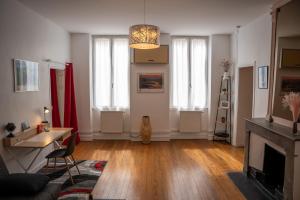 a living room with a fireplace and a table at L'Escapade-Spacieux -Climatisation-Centre Ville in Montélimar