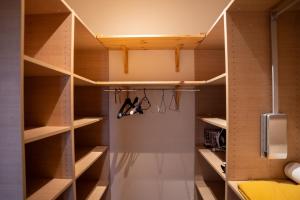 a walk in closet with wooden shelves at L'Escapade-Spacieux -Climatisation-Centre Ville in Montélimar