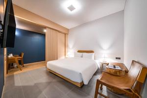 um quarto com uma cama, uma secretária e uma televisão em Hound Hotel Haeundae Signature em Busan