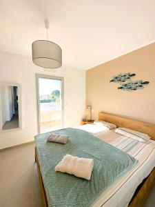 a bedroom with a bed with two towels on it at Duplex Marina Rossa in Lecci