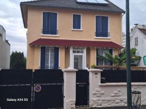 a house with a black fence in front of it at Studio équipé proche Stade de France in Épinay-sur-Seine