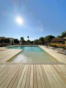 a large swimming pool with a wooden deck at Duplex Marina Rossa in Lecci