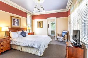 1 dormitorio con 1 cama y TV de pantalla plana en Bethany Manor B&B call them for Guaranteed Cheapest Price, en Leura