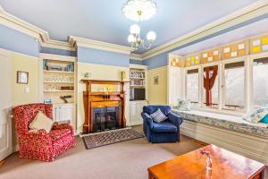 a living room with two chairs and a fireplace at Bethany Manor B&B call them for Guaranteed Cheapest Price in Leura