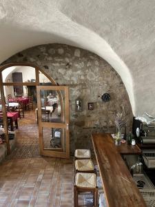 Zimmer mit einer Steinmauer, einem Tisch und einem Spiegel in der Unterkunft Auberge du désert 