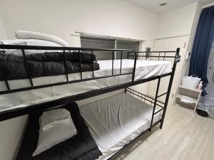 um quarto com dois beliches em um quarto em Meguro Apartment em Tóquio