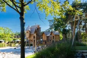 a playground at a park with wooden houses at Vakantiepark Molenvelden in Veldhoven