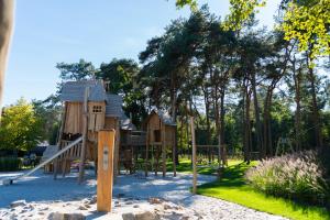 um parque com um parque infantil de madeira com escorrega em Vakantiepark Molenvelden em Veldhoven