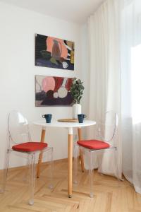 クラクフにあるBeautiful & Cozy Apartment next to Main Marketのテーブルと椅子2脚、テーブルと絵画