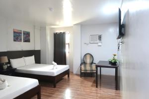 a hotel room with a bed and a chair at COCOS HOTEL in Compostela