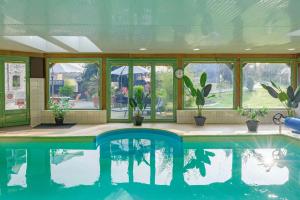 una piscina en una casa con macetas en Les Pierres Bleues en Saint-Coulitz
